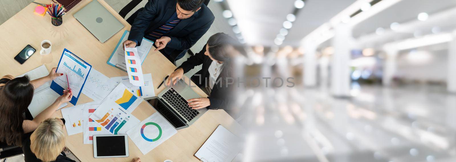 Business people group meeting shot from top widen view in office . Profession businesswomen, businessmen and office workers working in team conference with project planning document on meeting table .