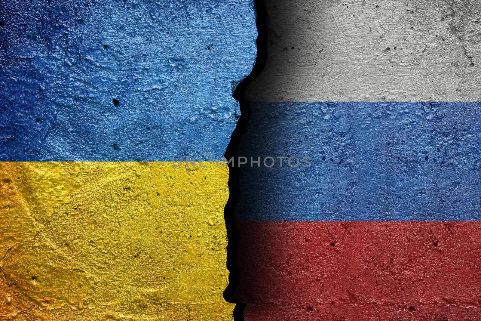 Ukraine and Russia - Cracked concrete wall painted with a Ukrainian flag on the left and a Russian flag on the right stock photo by adamr