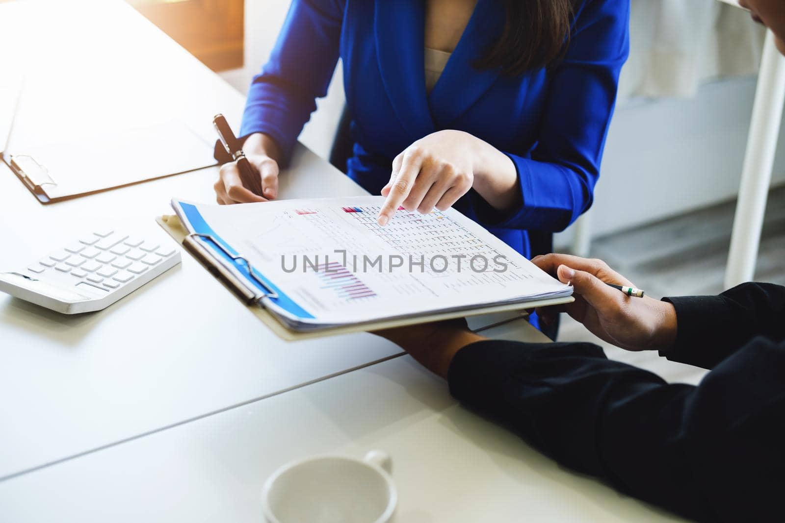 negotiation, analysis, discussion,asian female economist pointing out a document explaining the investment finance program to the company owner to plan marketing and hedging business risks