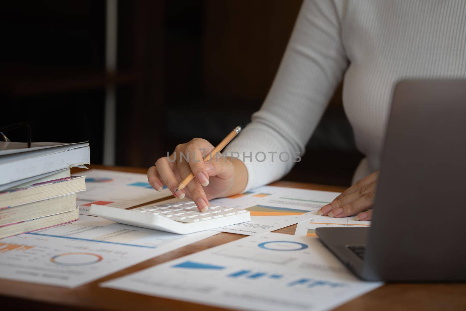 Consult financial concept. Business woman pointing at paperwork and using calculator on desk at office. back to office.