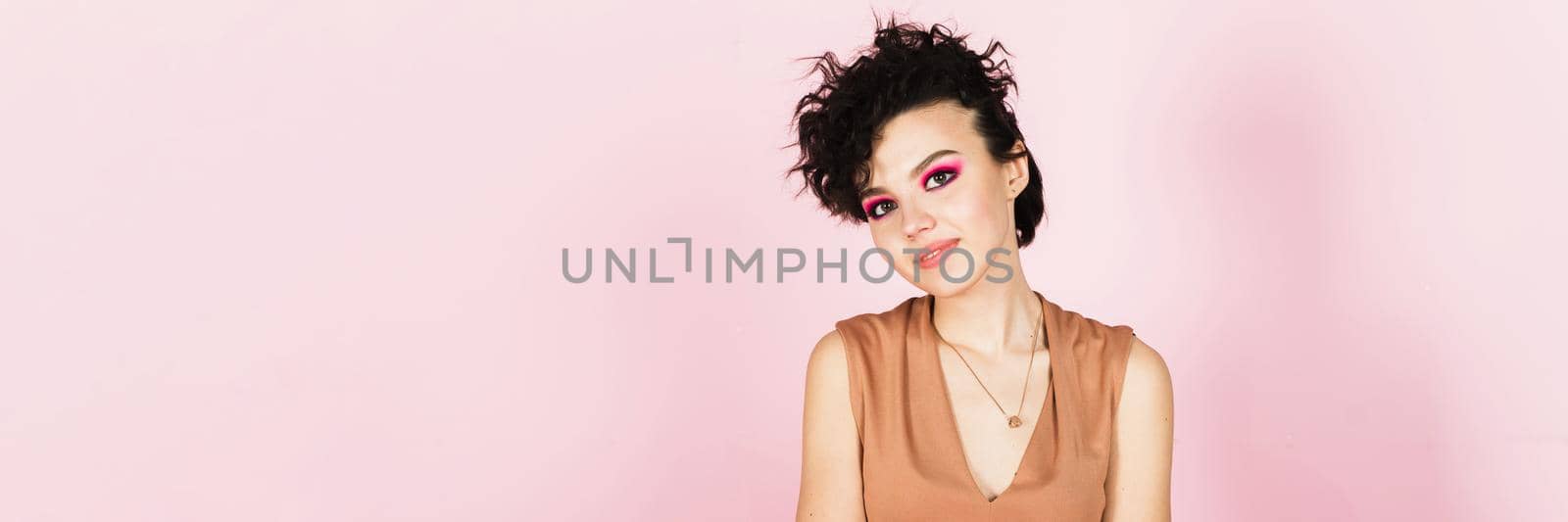 Portrait of a beautiful model with bright pink make-up and bright flying hair. Beautiful lips and makeup. Sexy girl with short hair. Web banner.