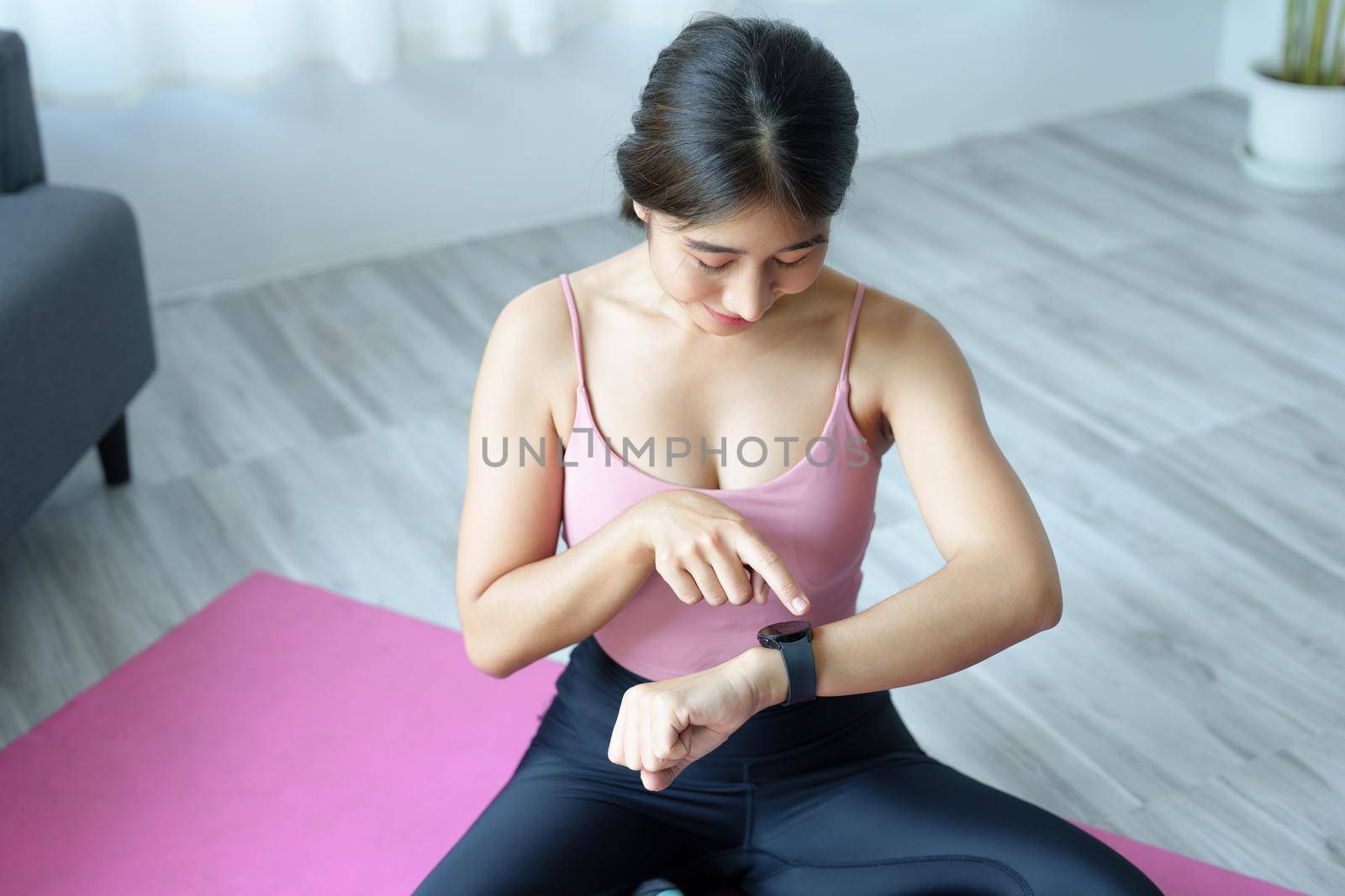 Health care, heart rate monitor, portrait of Asian beautiful woman using smart watch to select health programs such as yoga, cardio exercises, breathing meditation. to prepare before the activity