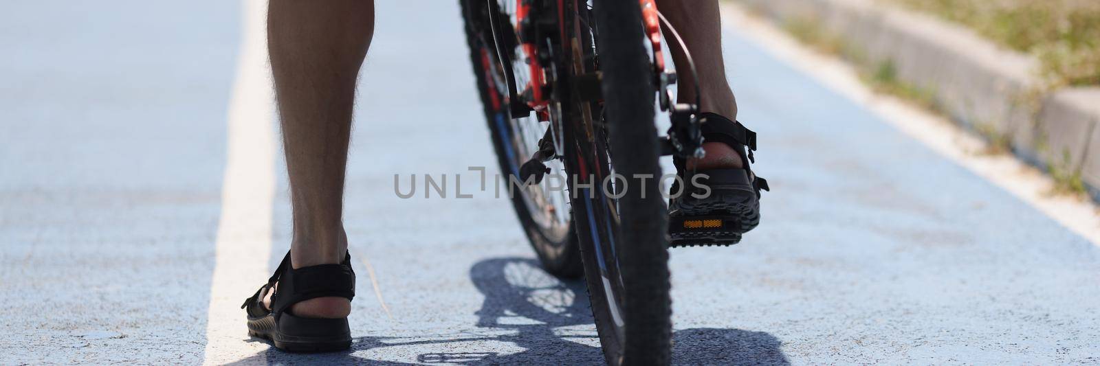 Male legs of a cyclist on the asphalt, bike stop by kuprevich