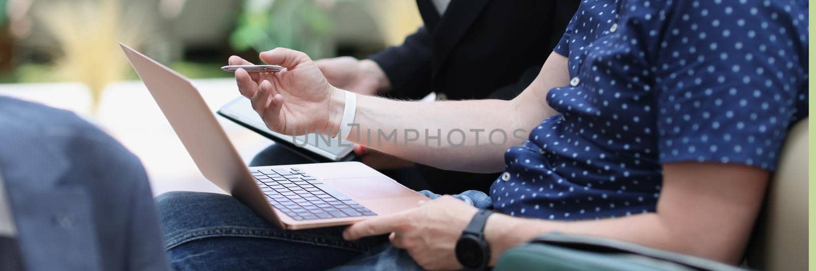 A man with a laptop and a woman with a tablet are talking by kuprevich