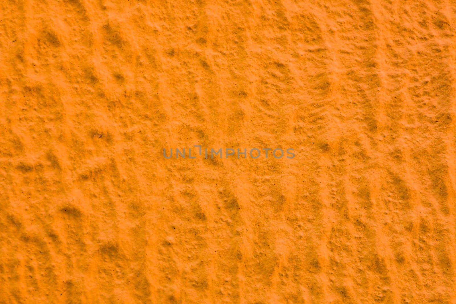 Uneven abstract texture of yellow paint. Abstract background of orange plaster.