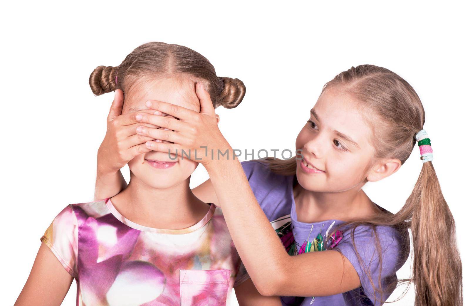 Children play and joke. One girl closes the eyes of another. Photo isolated on white background by aprilphoto