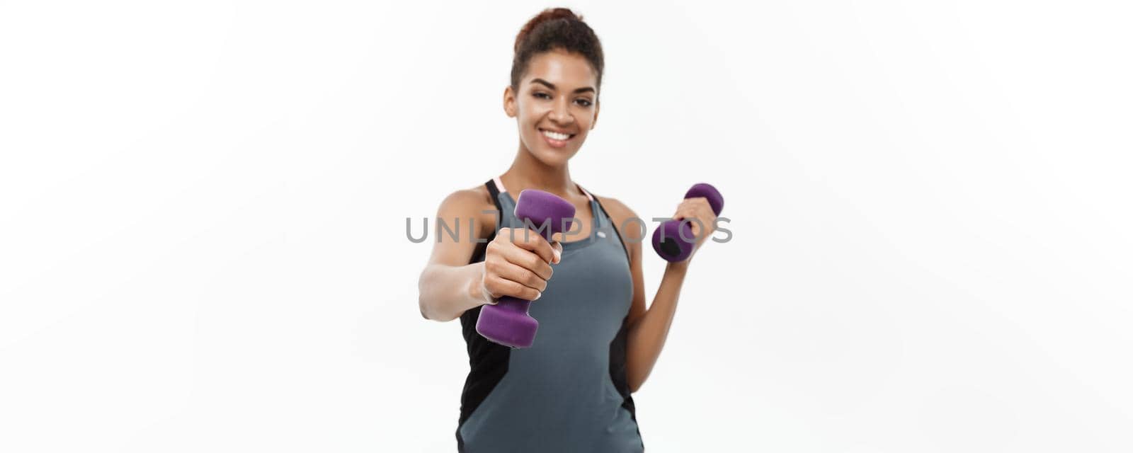 Healthy and Fitness concept - Beautiful American African lady in fitness clothes workout with dumbbell. Isolated on white background