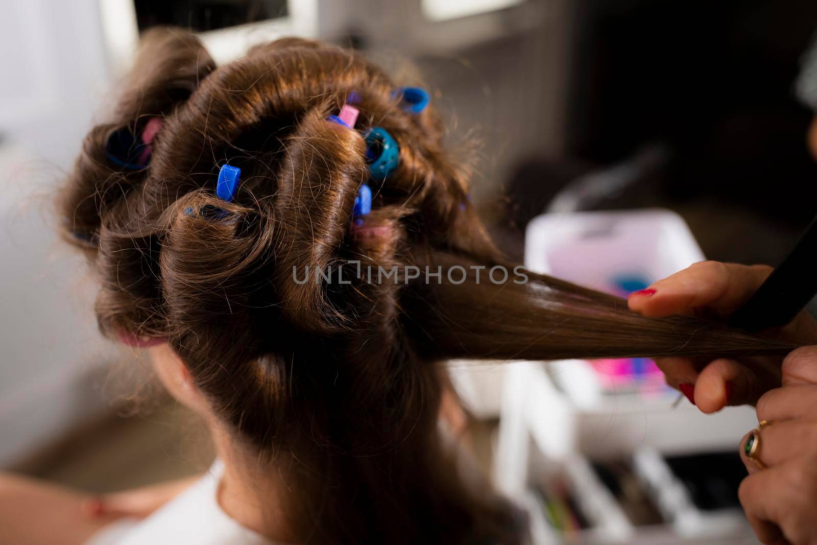 Close up of the hair of a female customer being curled during a hairdressing session at the hair salon
