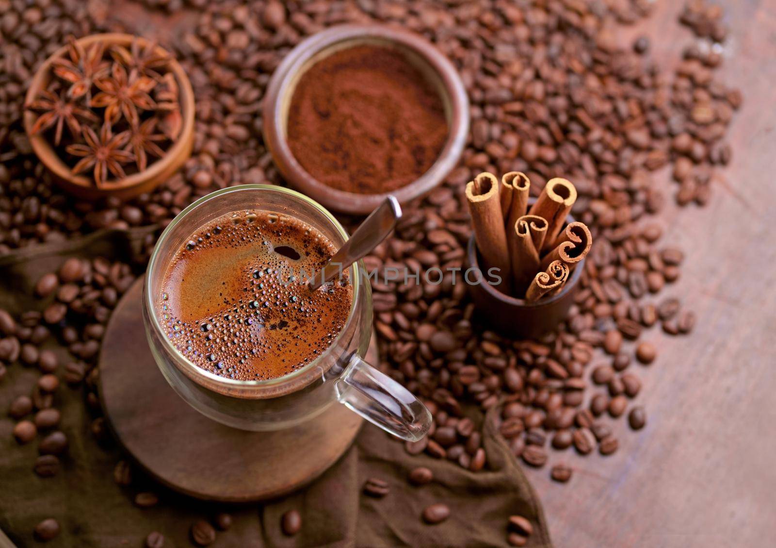 Hot black coffee and coffee beans on the old wooden table