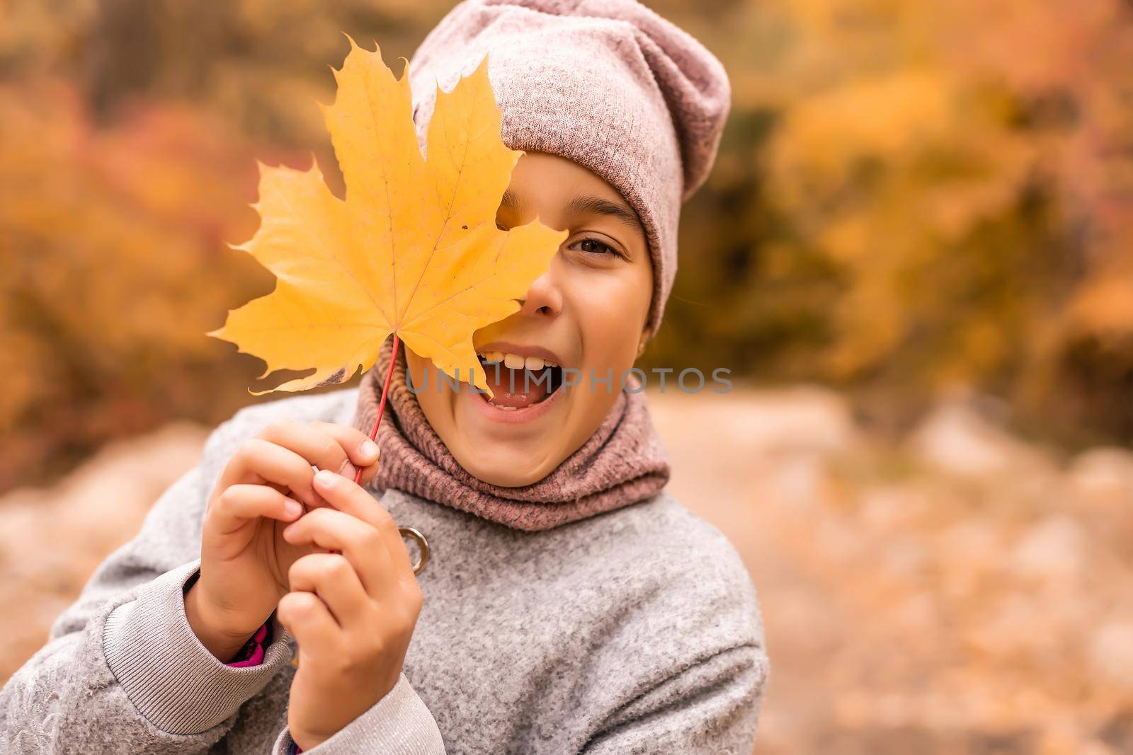 Kids play in autumn park. Children throwing yellow leaves. Child girl with maple leaf. Fall foliage. Family outdoor fun in autumn. Toddler or preschooler in fall.