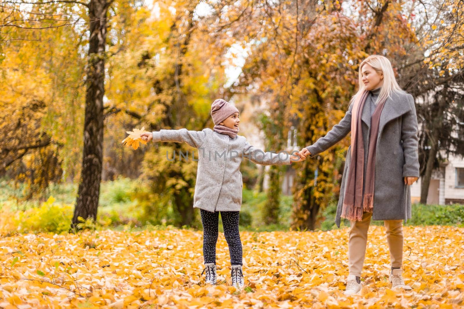 Mother and daughter in autumn yellow park