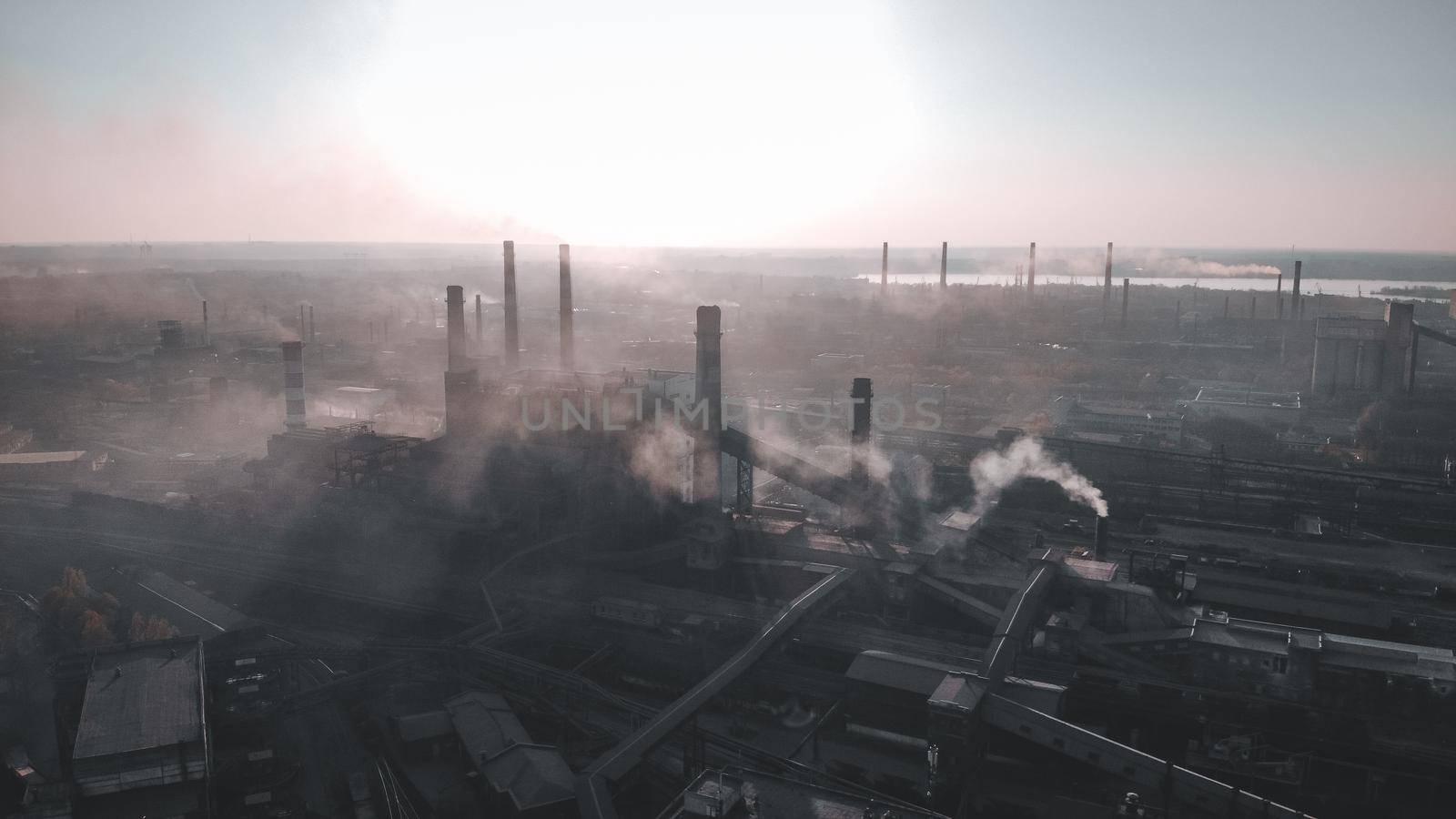 Steel industrial,heavy industry plant Industrial zone , pipeline steel with smoke . sunset and cloudy sky on background. Aerial view. Mordor