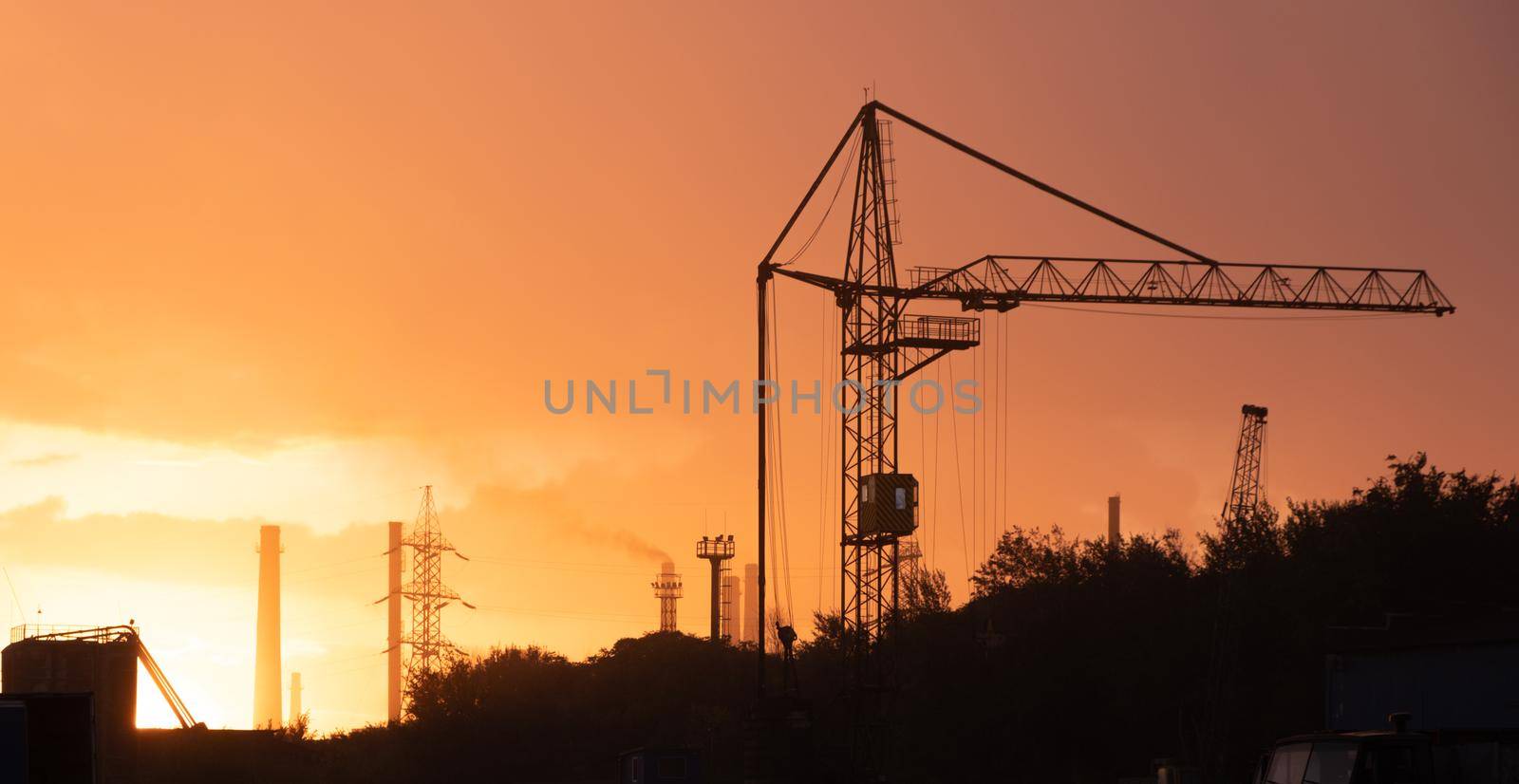 Factory with crane on sunrise, industrial background