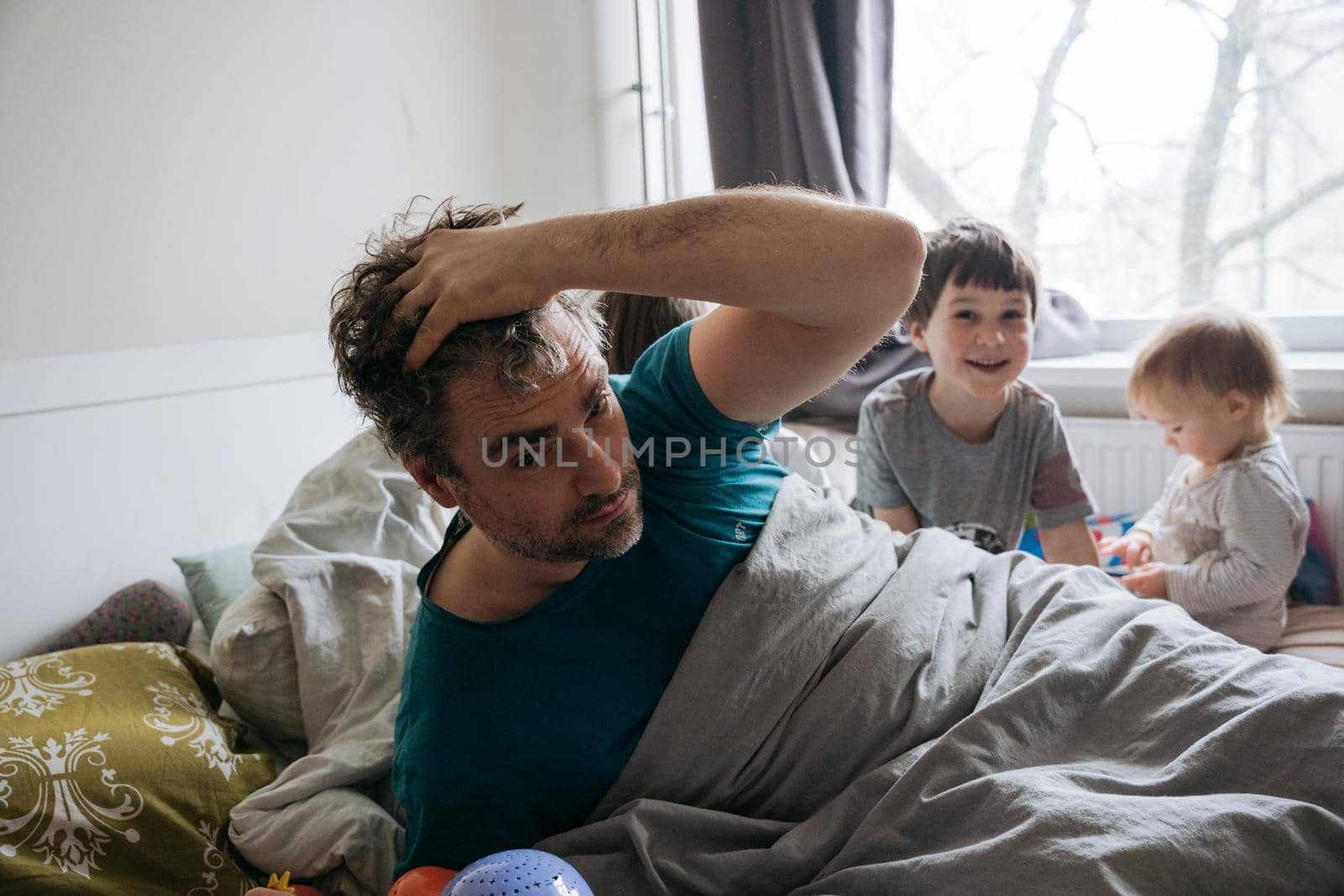Mature man waking up surrounded with children by Varaksina