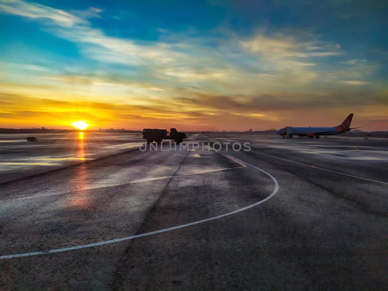 Empty runway, airstrip in the airport. Travel aviation concept. Fuel tanker on airstrip at the sunrise. Virus effect