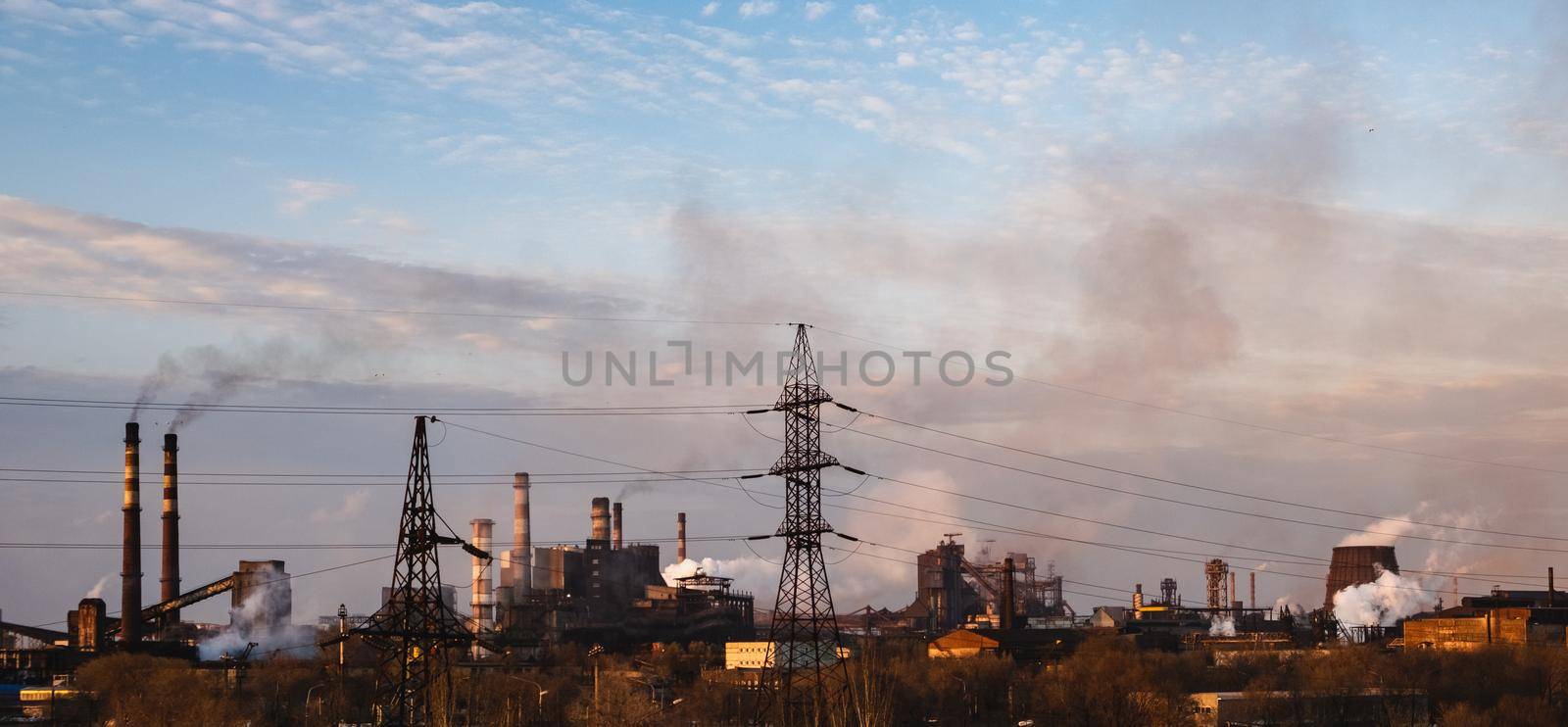 Chemical plant polluting air, smoke from chimneys. High power electricity poles in urban area. Panorama global warming