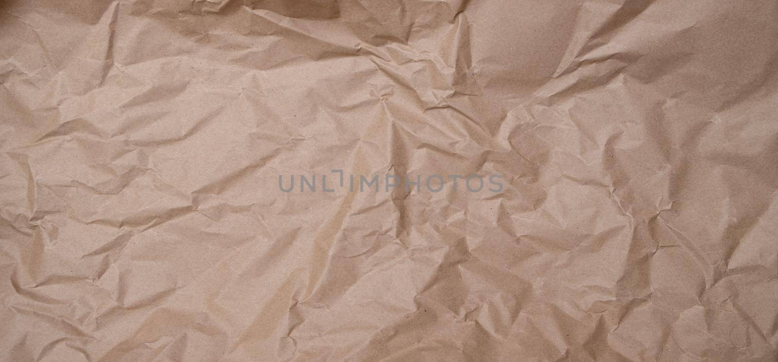 crumpled brown blank paper. Rumpled brown cardboard paper texture background