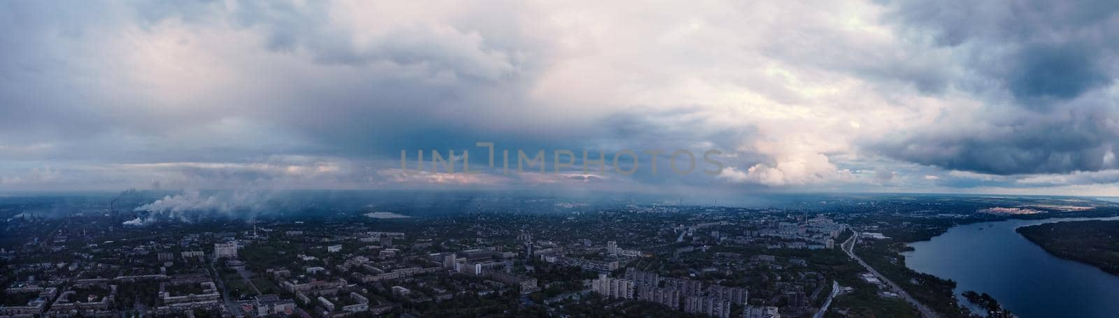 panoramic view of the city with river from above. Smog from industrial zone over city. aerial view on the city. panorama of city with clouds
