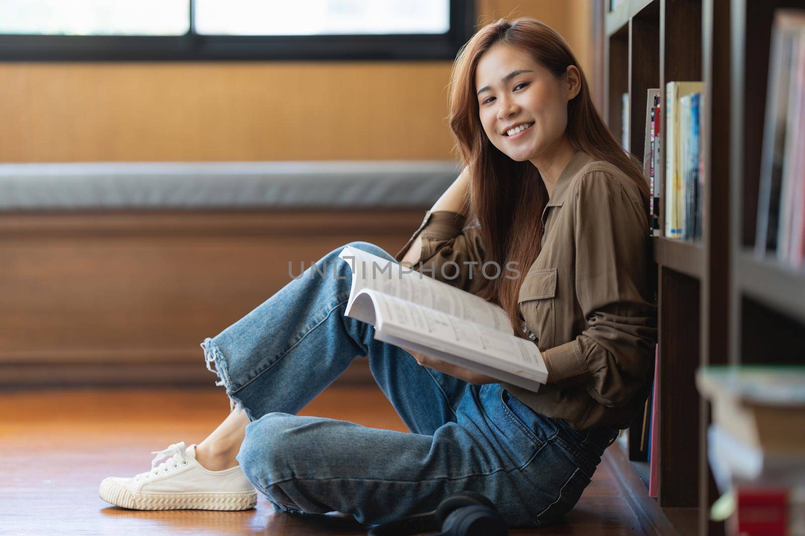 Back to school concept. Asian student reading book in library at school