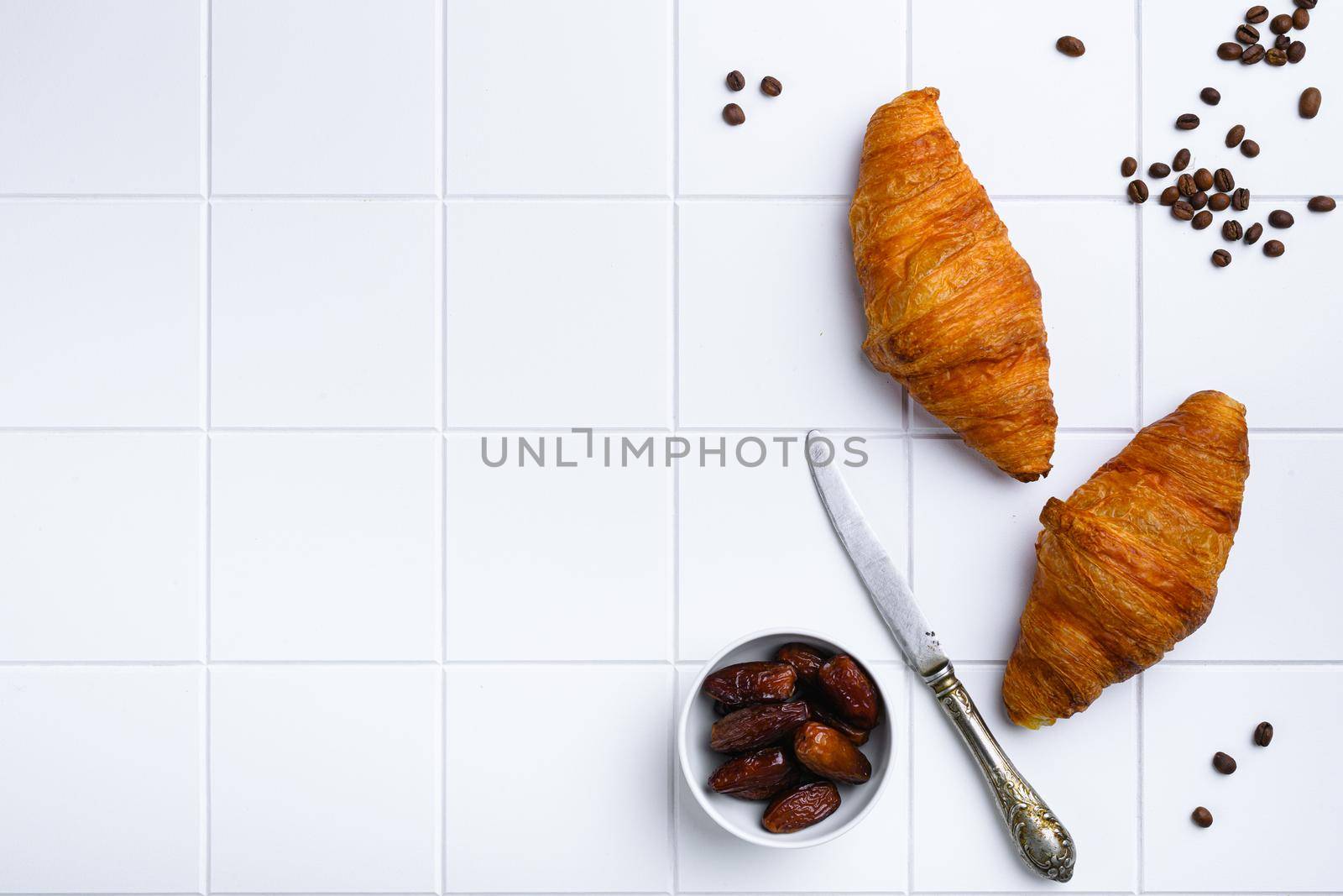 Fresh baked croissant set, on white ceramic squared tile table background, top view flat lay, with copy space for text by Ilianesolenyi