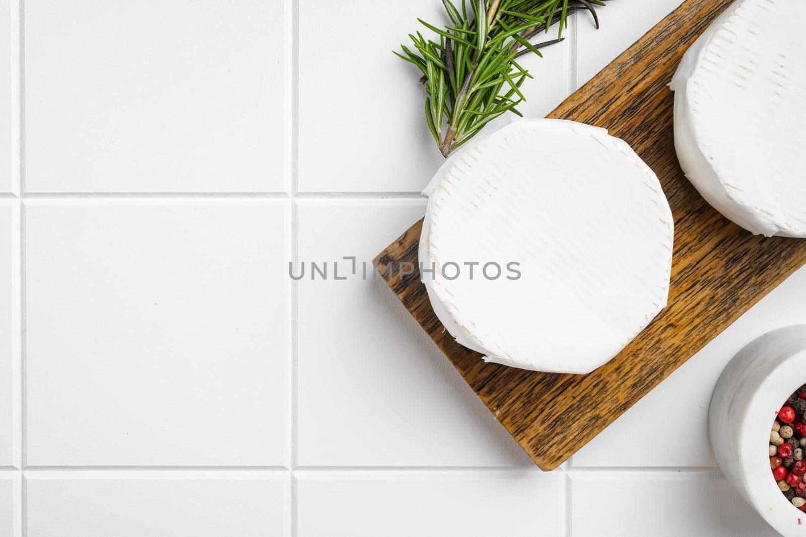 Camembert and brie cheese on white ceramic squared tile table background, top view flat lay, with copy space for text by Ilianesolenyi