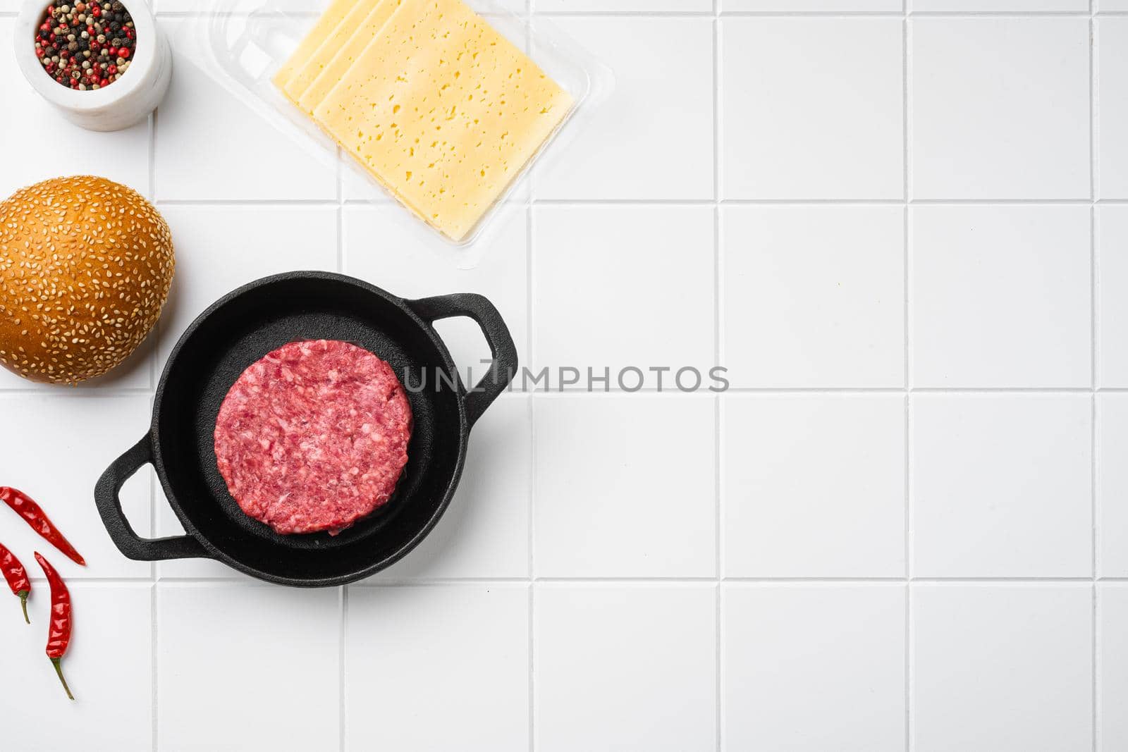 Fresh Raw Minced Homemade Grill Beef Steak Burgers, on white ceramic squared tile table background, top view flat lay, with copy space for text