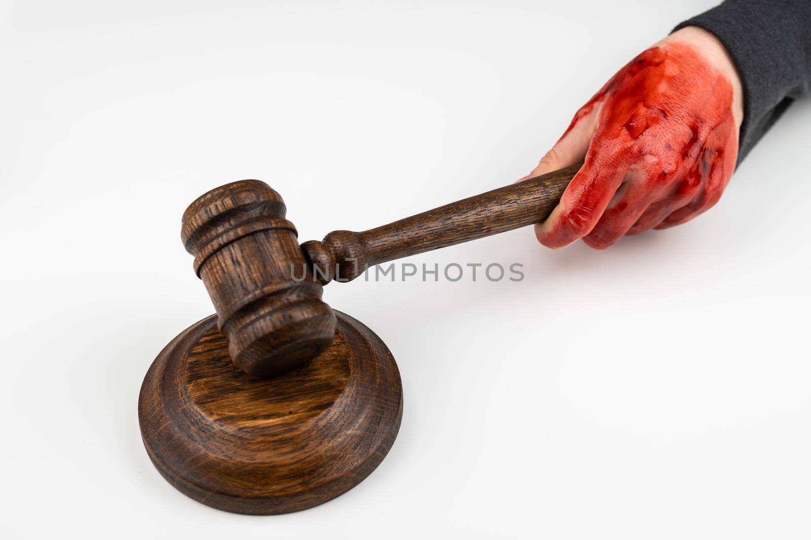 Female judge with bloody hands beats the gavel on a white background