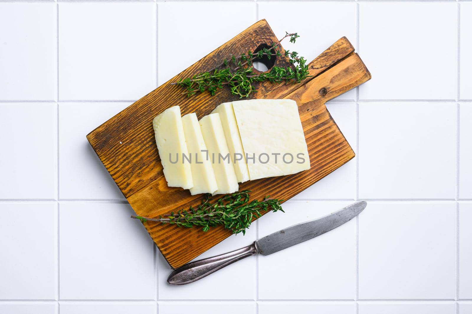 Cyprus Halloumi cheese, on white ceramic squared tile table background, top view flat lay, with copy space for text