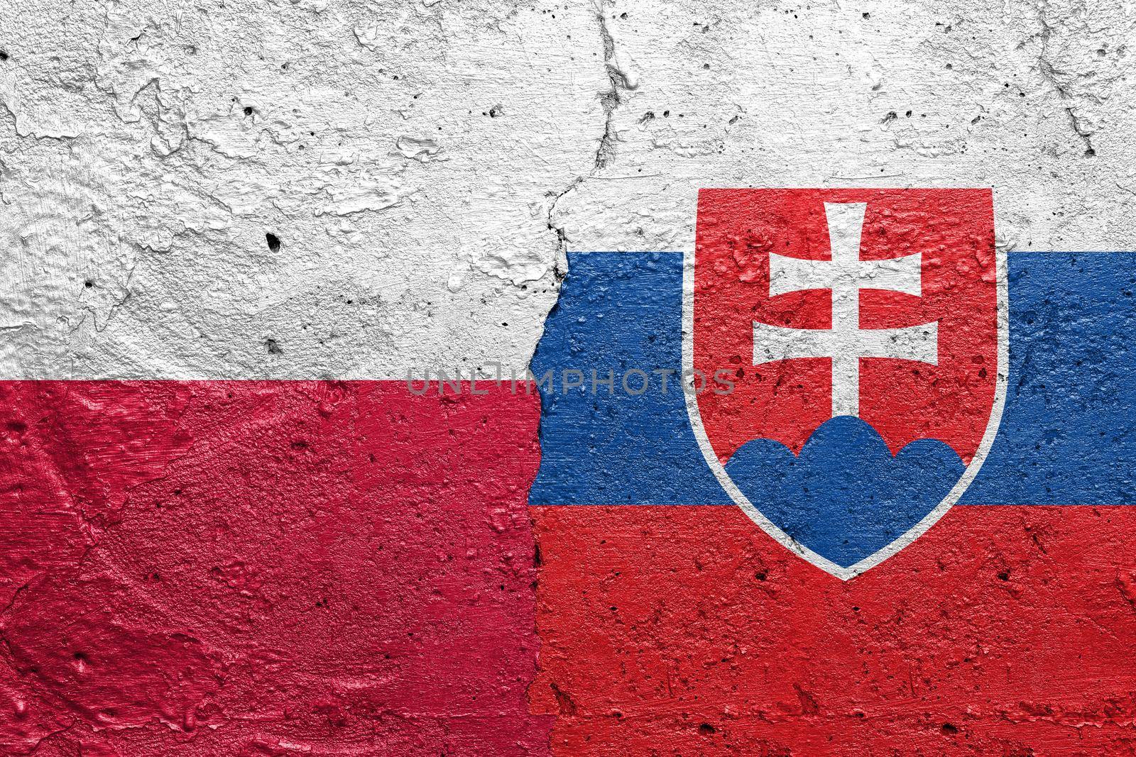 Poland and Slovakia - Cracked concrete wall painted with a Polish flag on the left and a Slovakian flag on the right stock photo by adamr