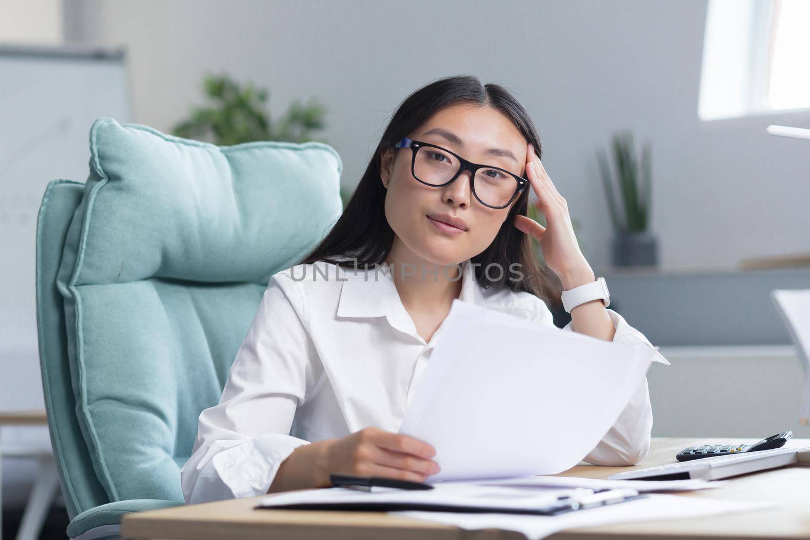 Business woman working in office with documents, thinking about financial reports, Asian businesswoman boss.