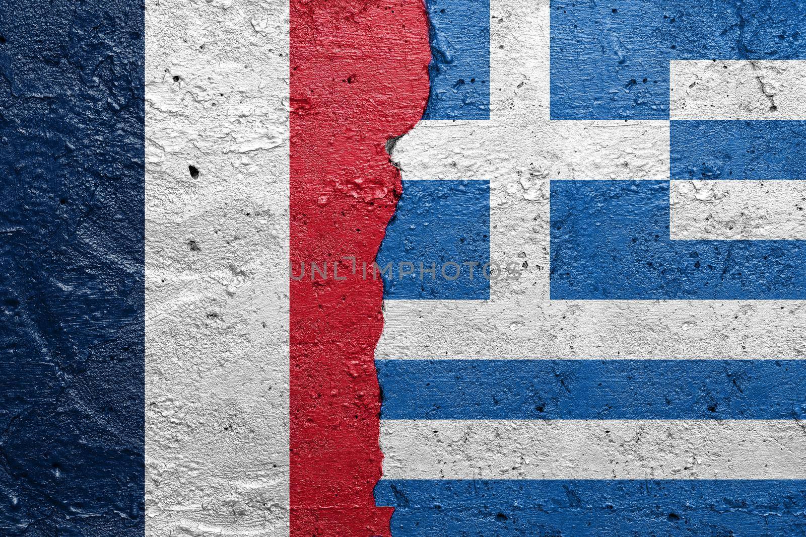 France and Greece - Cracked concrete wall painted with a French flag on the left and a Greek flag on the right stock photo by adamr