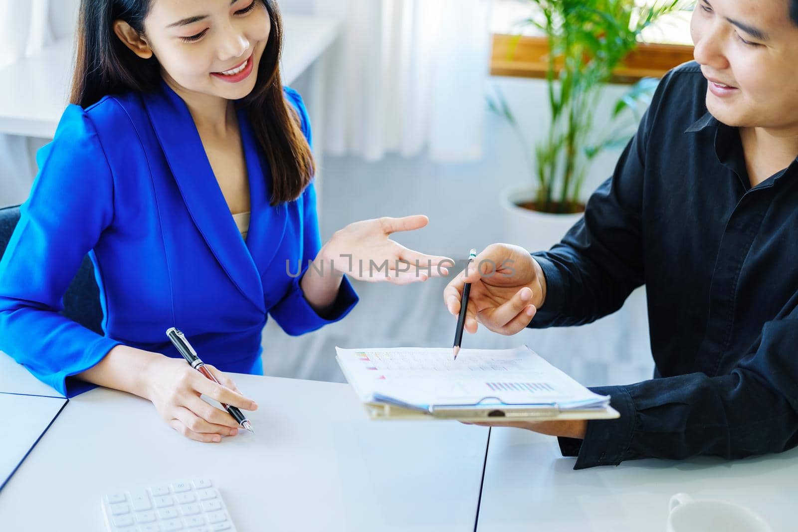 negotiation, analysis, discussion,asian male economist pointing out a document explaining the investment finance program to the company owner to plan marketing and hedging business risks