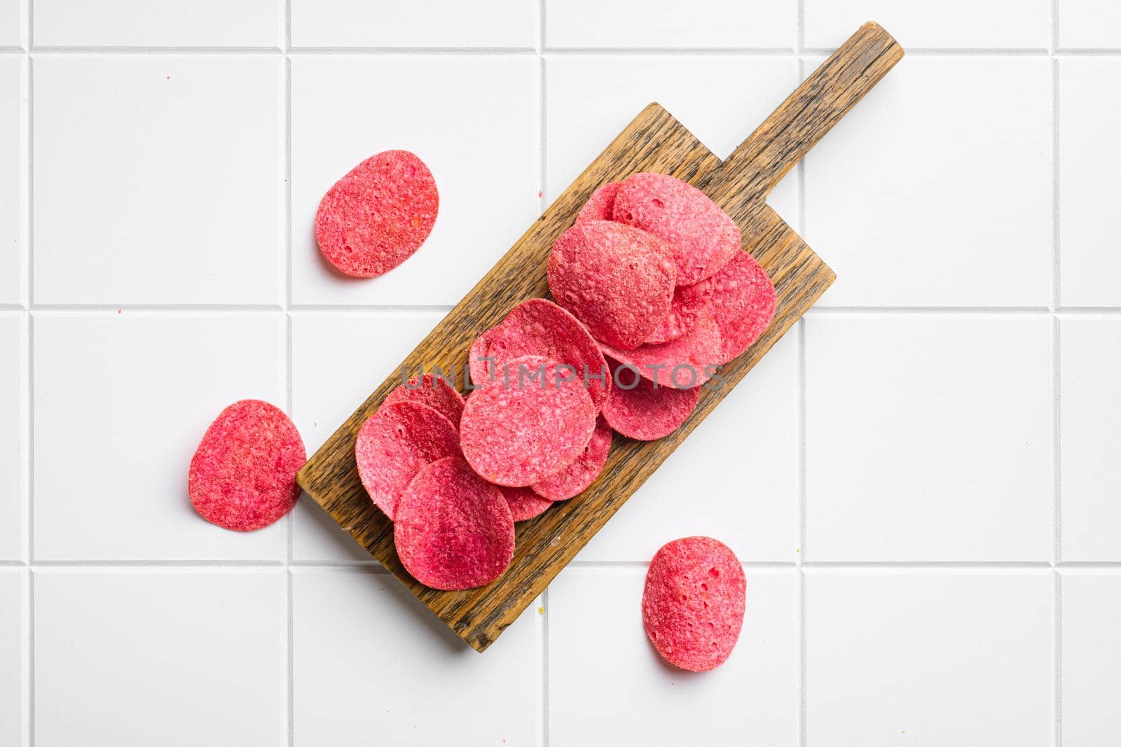 Red potato chips, on white ceramic squared tile table background, top view flat lay, with copy space for text