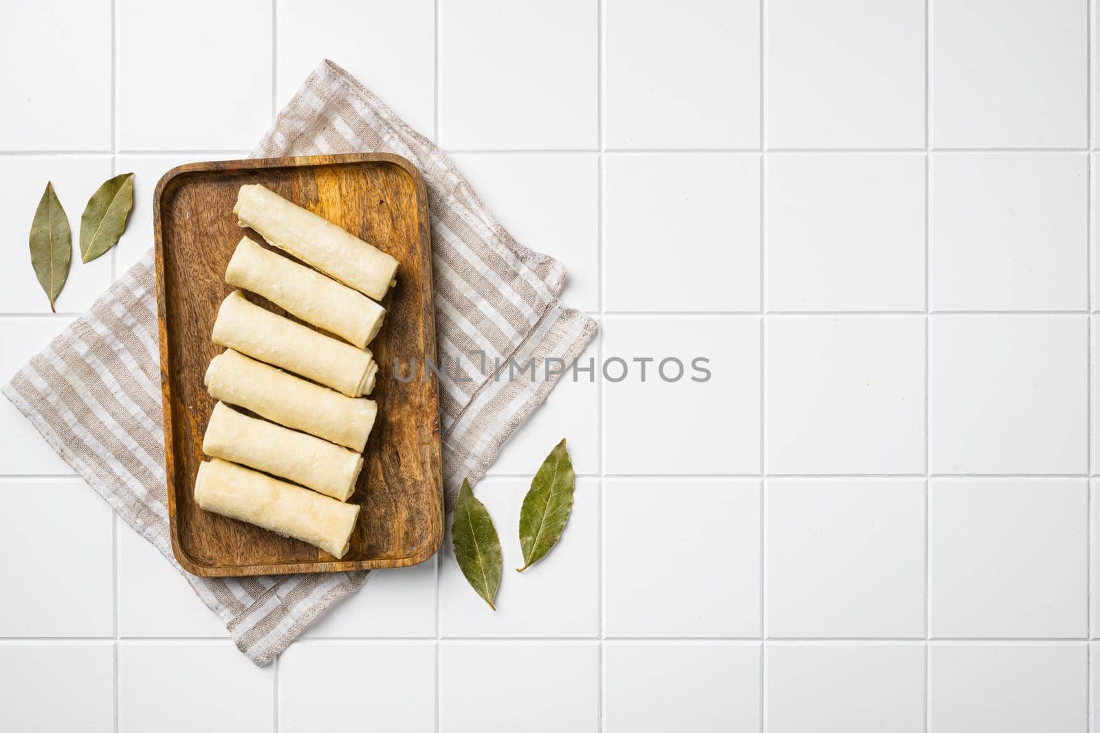 Semi finished pancakes, on white ceramic squared tile table background, top view flat lay, with copy space for text