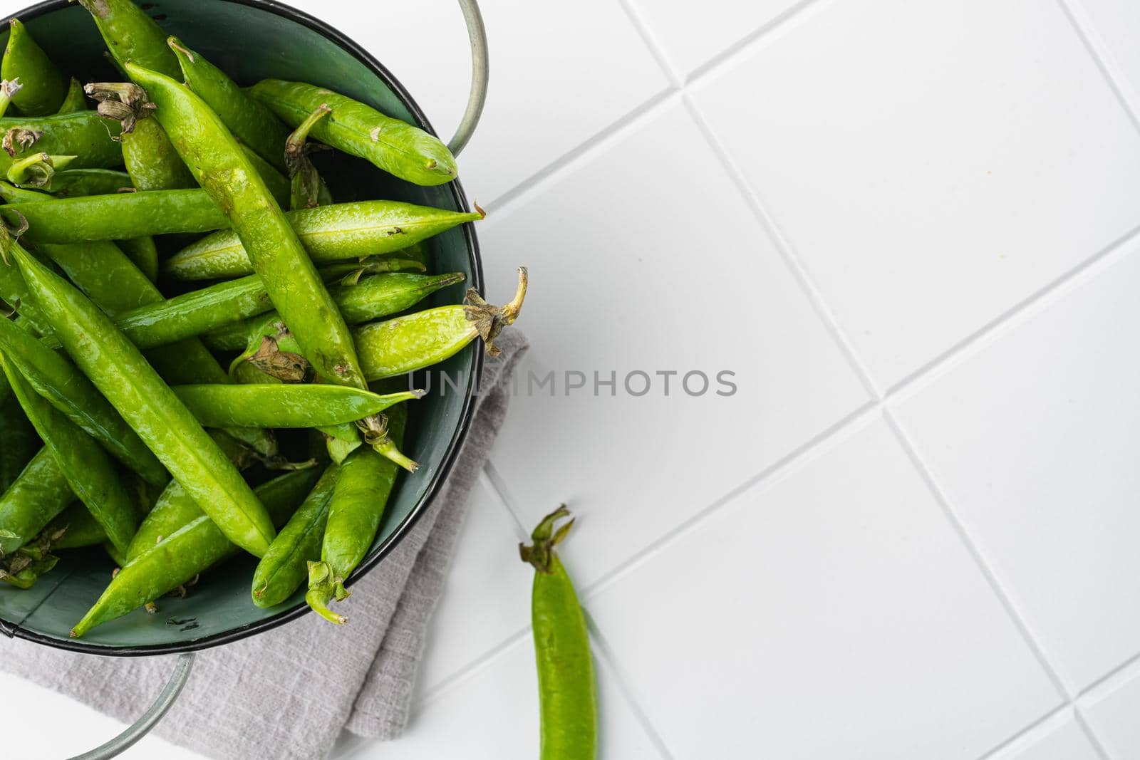 Fresh picked green pea on white ceramic squared tile table background, top view flat lay, with copy space for text by Ilianesolenyi