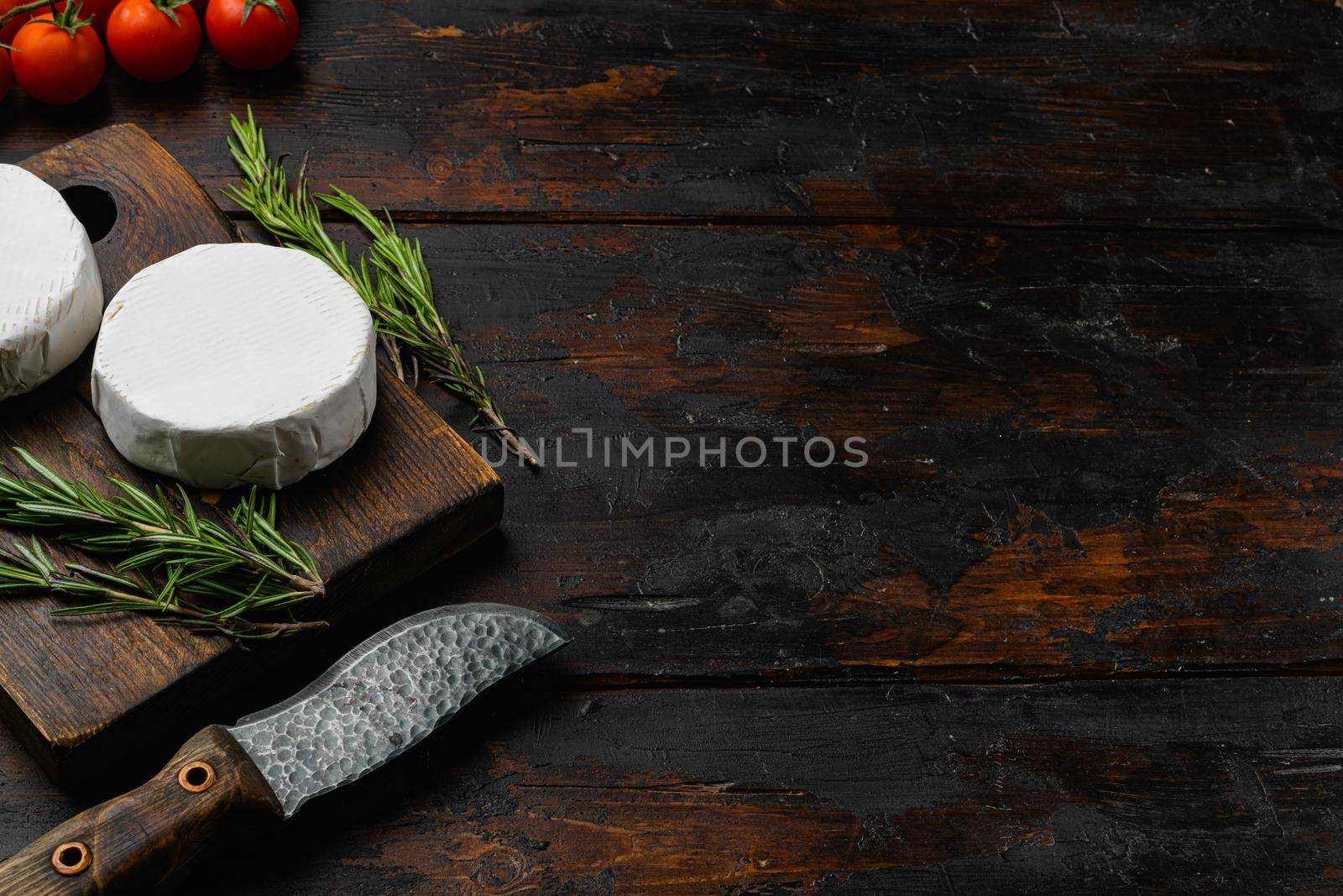 Camembert cheese, on old dark wooden table background, with copy space for text