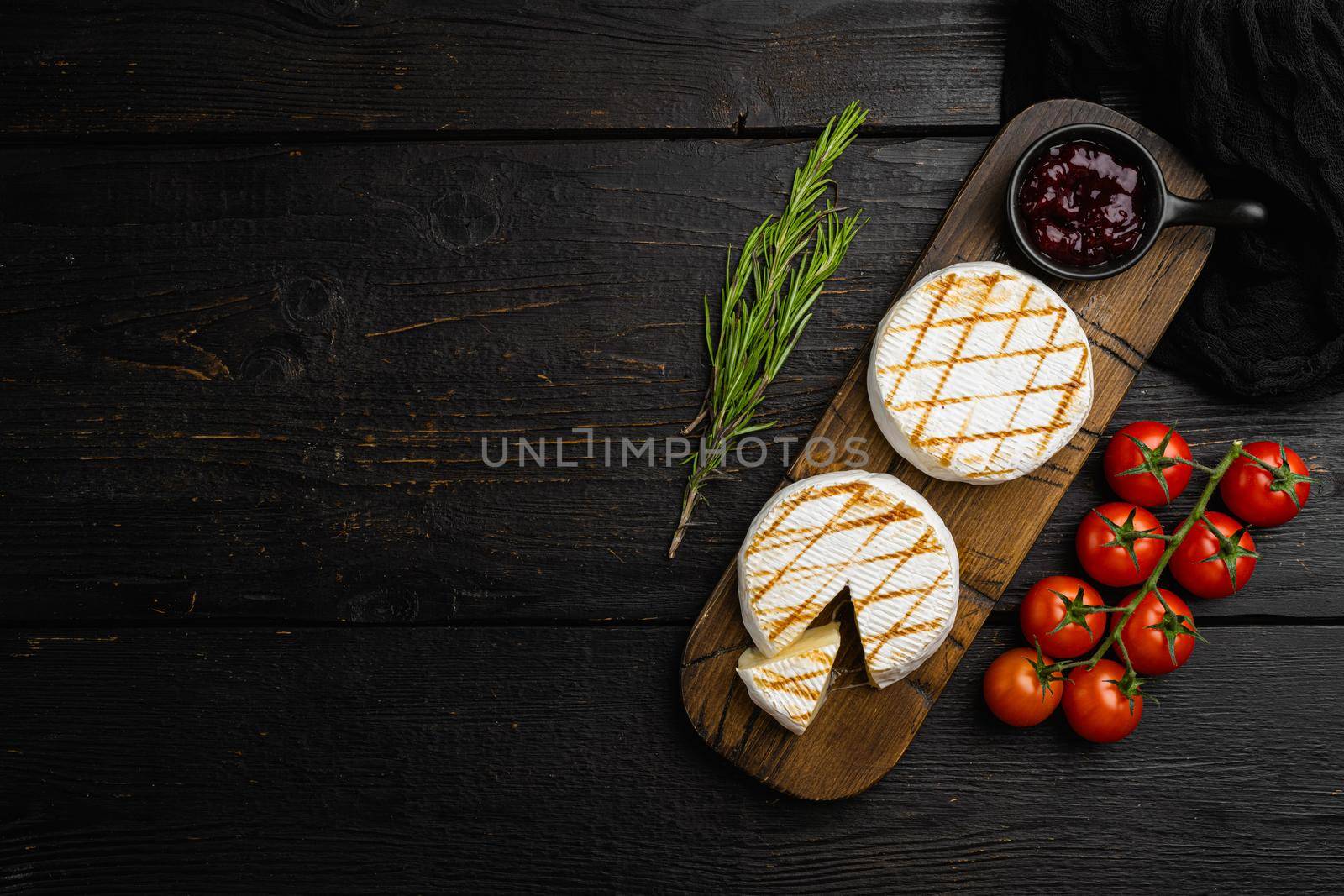 Homemade Baked Camembert cheese on black wooden table background, top view flat lay, with copy space for text by Ilianesolenyi