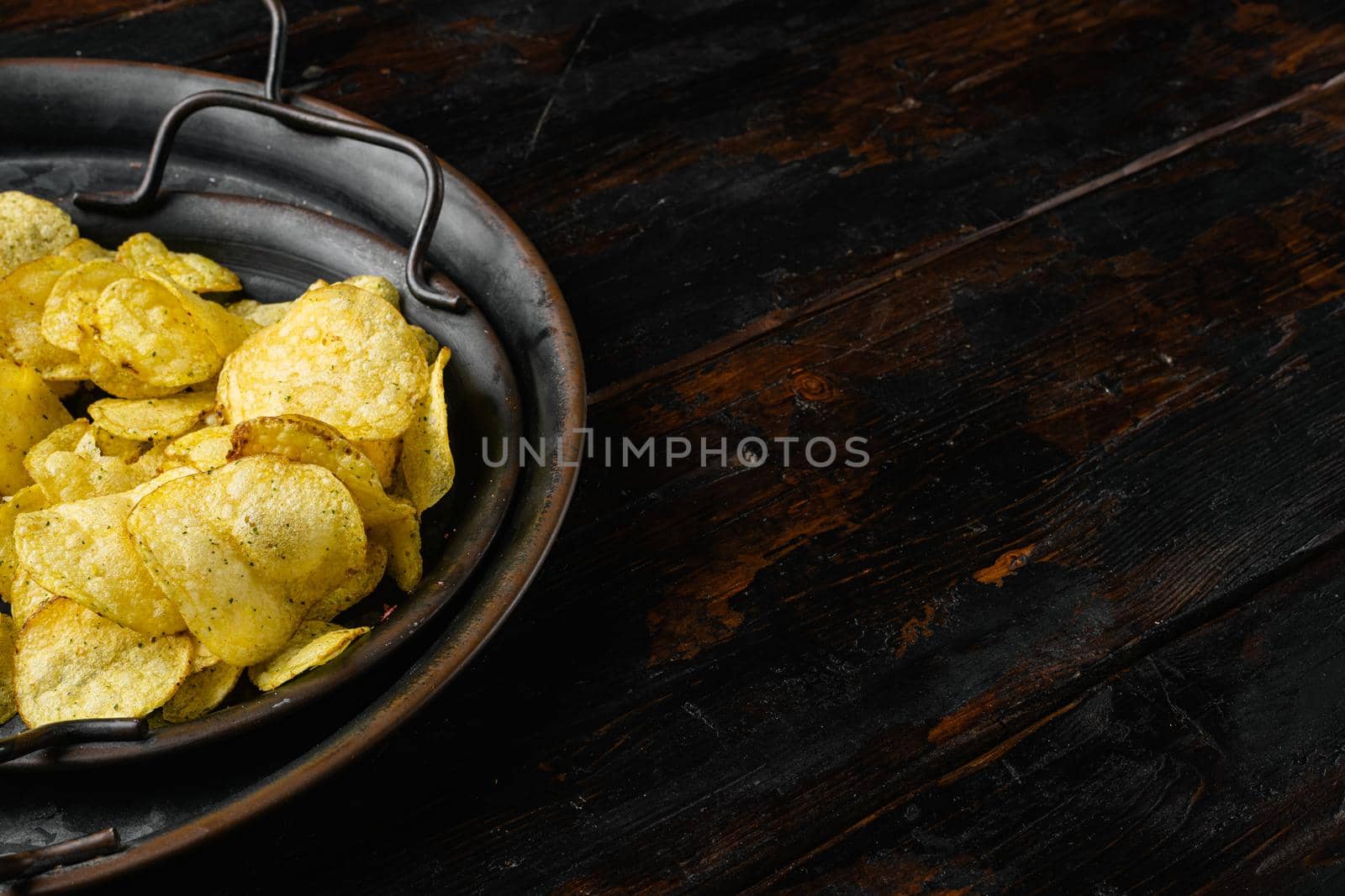 Root Classic potato chips, on old dark wooden table background, with copy space for text