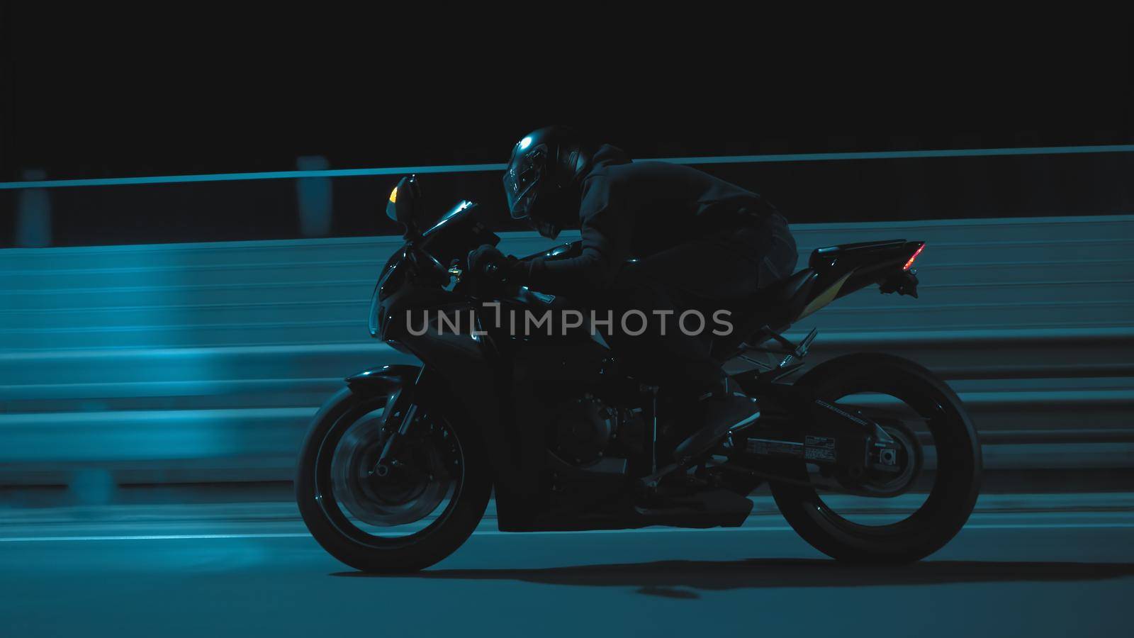 A man rides a sports motorcycle through the city at night in 4k