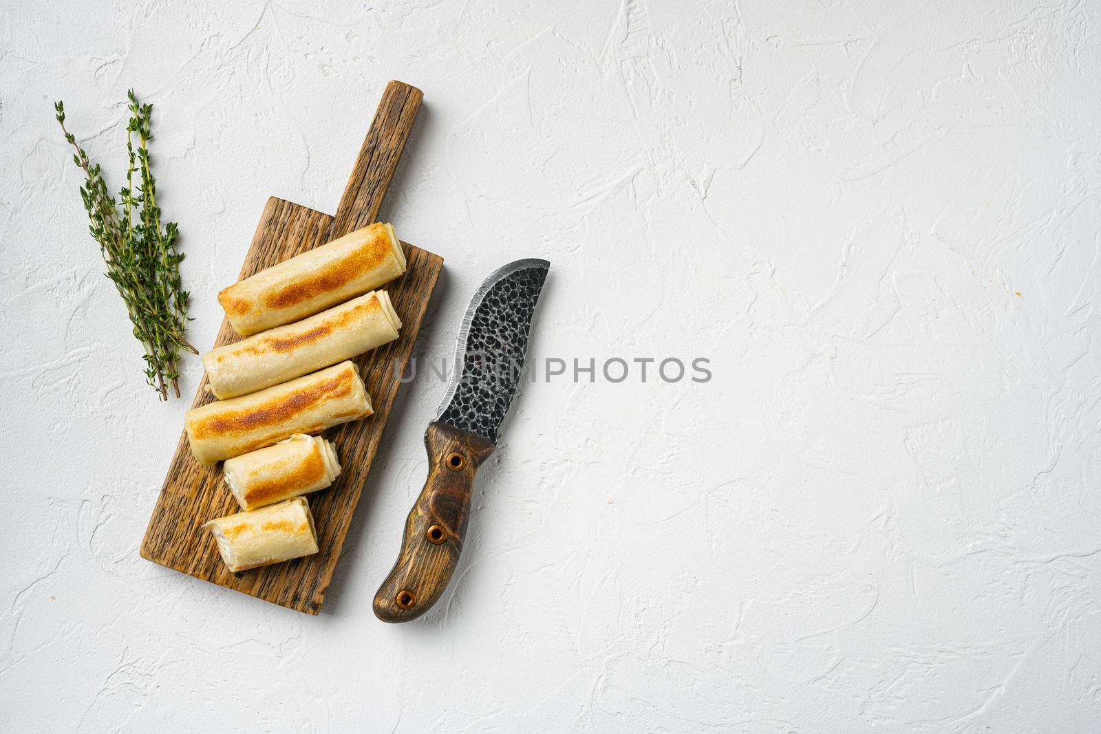 Fired pancakes with salted filling, sour crepes on white stone table background, top view flat lay, with copy space for text by Ilianesolenyi