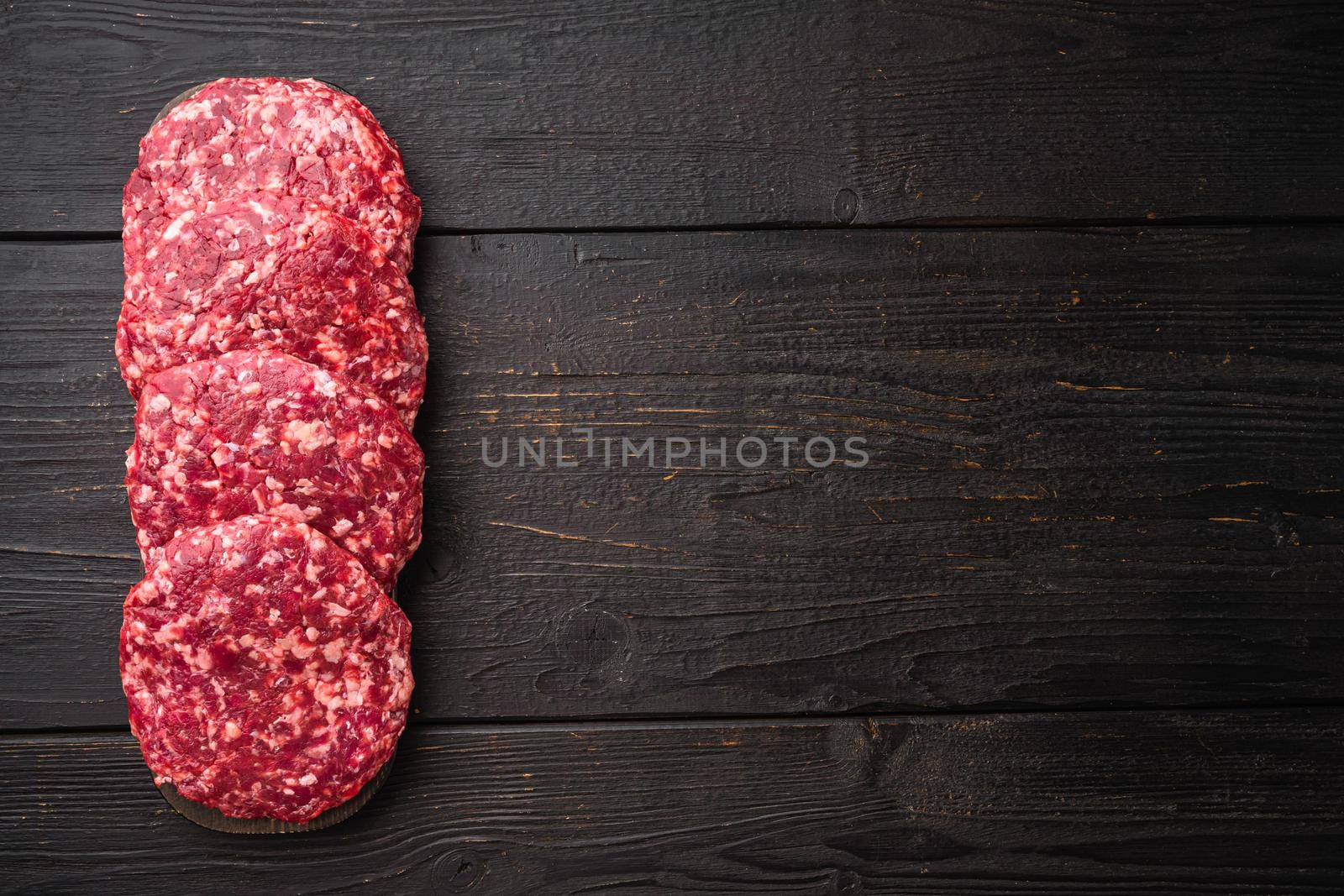 Patty of minced meat for burger set, on black wooden table background, top view flat lay, with copy space for text