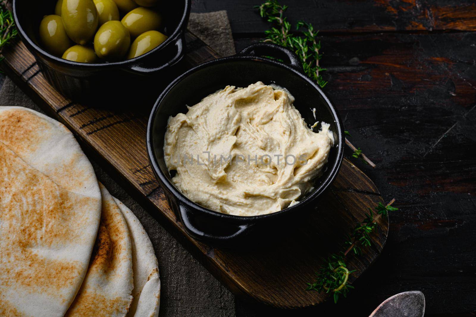 Hummus and wheat flatbread set, on old dark wooden table background, with copy space for text by Ilianesolenyi