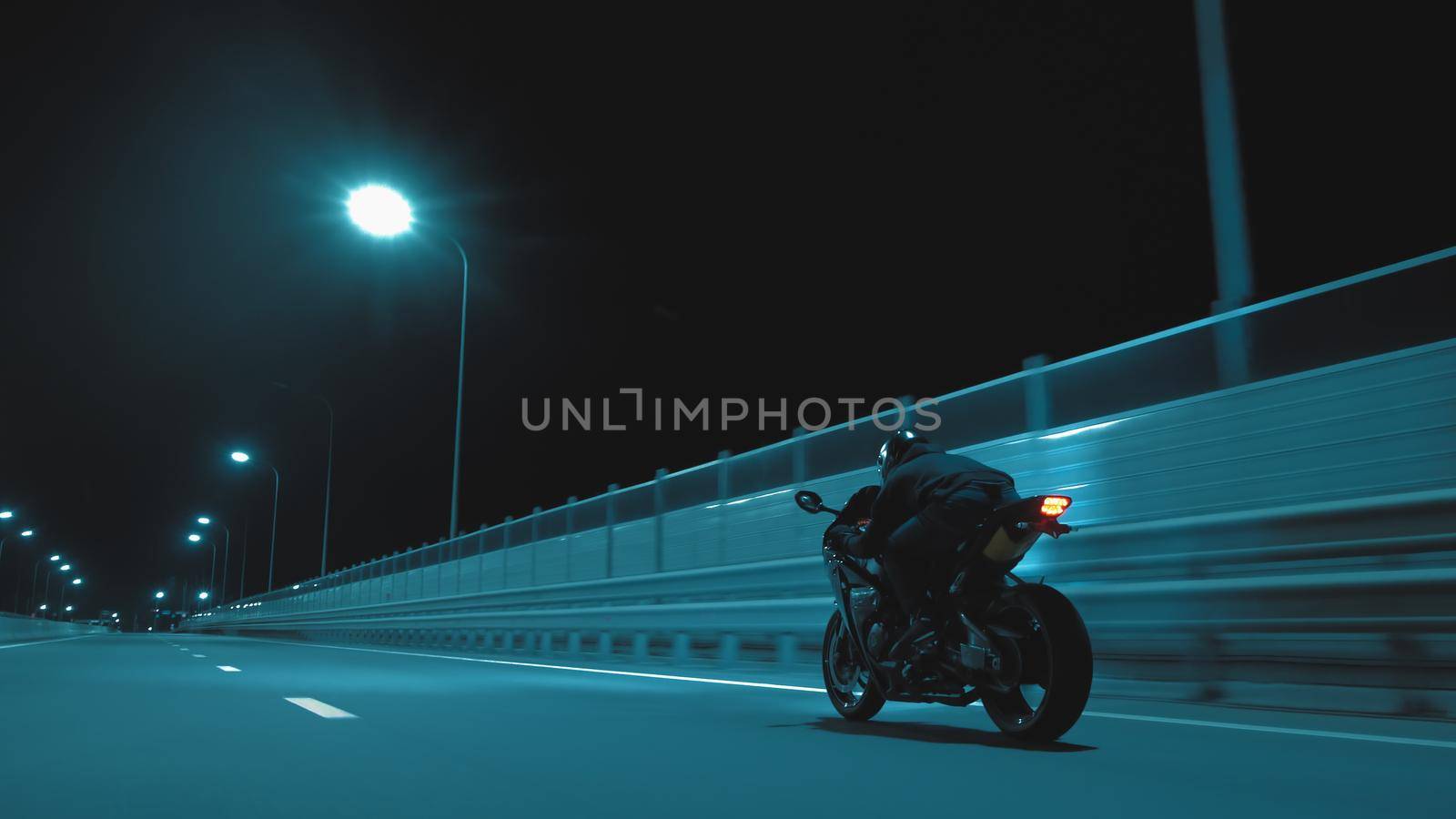 A man rides a sports motorcycle on a night track by studiodav