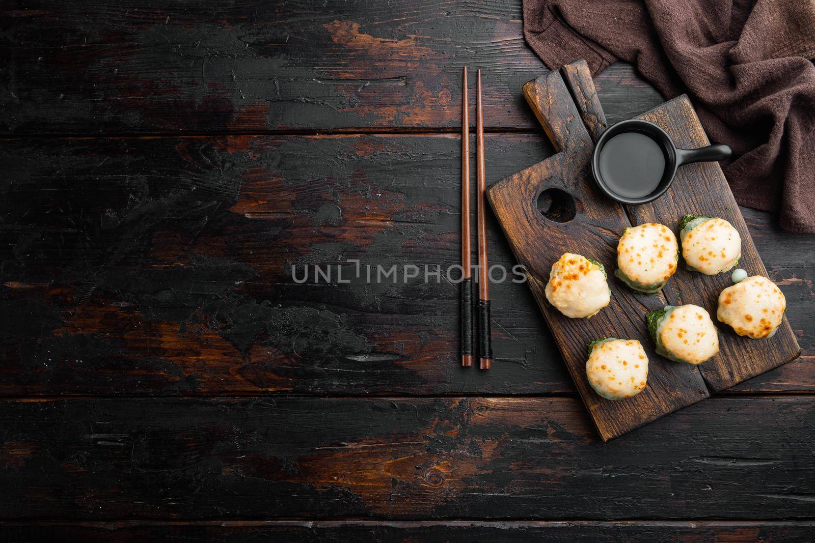 Fresh Sushi rolls with wasabi and ginger, on old dark wooden table background, top view flat lay , with copyspace and space for text by Ilianesolenyi