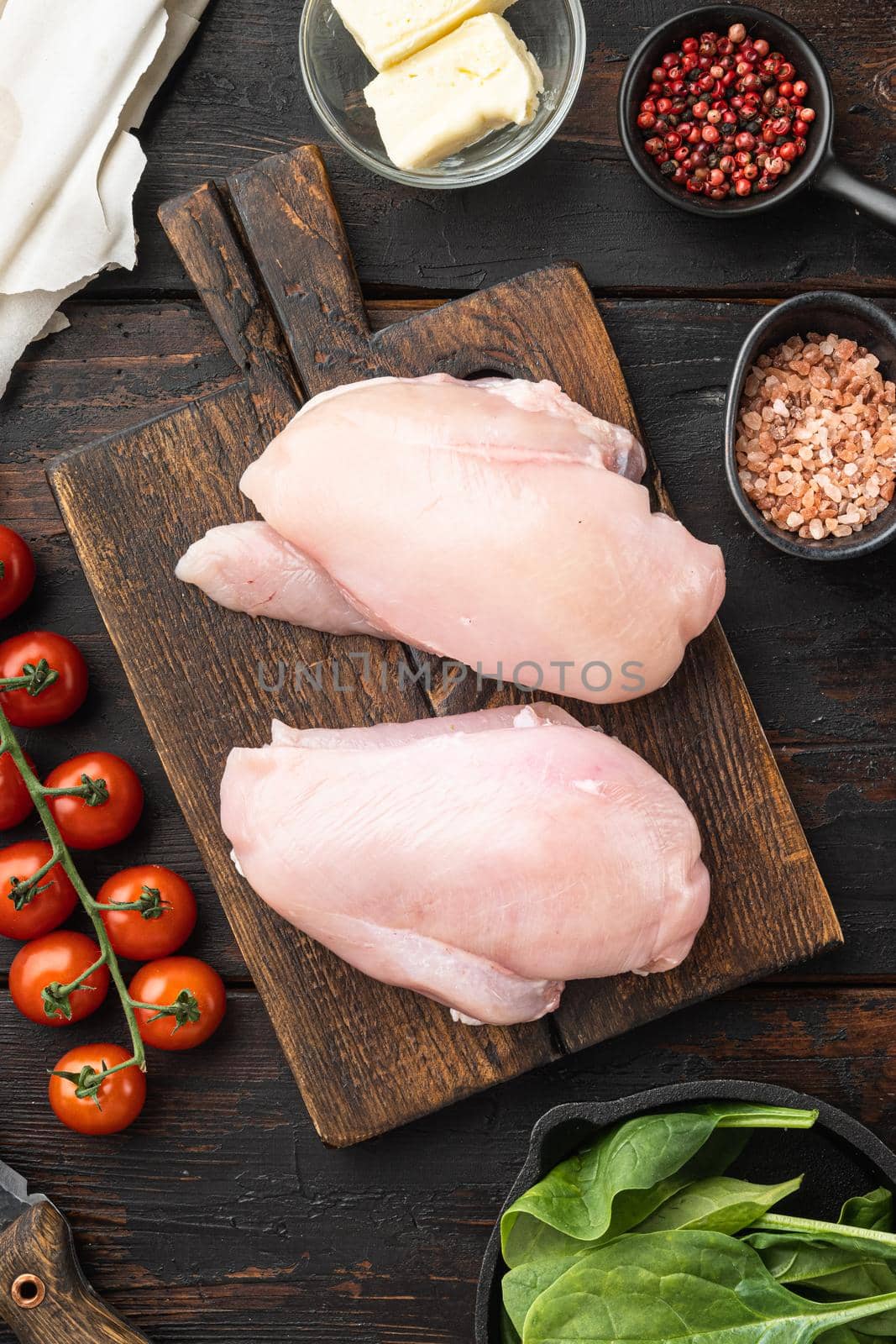 Raw Chicken meat stuffed ingredients with filo, herbs, butter set, on old dark wooden table background, top view flat lay