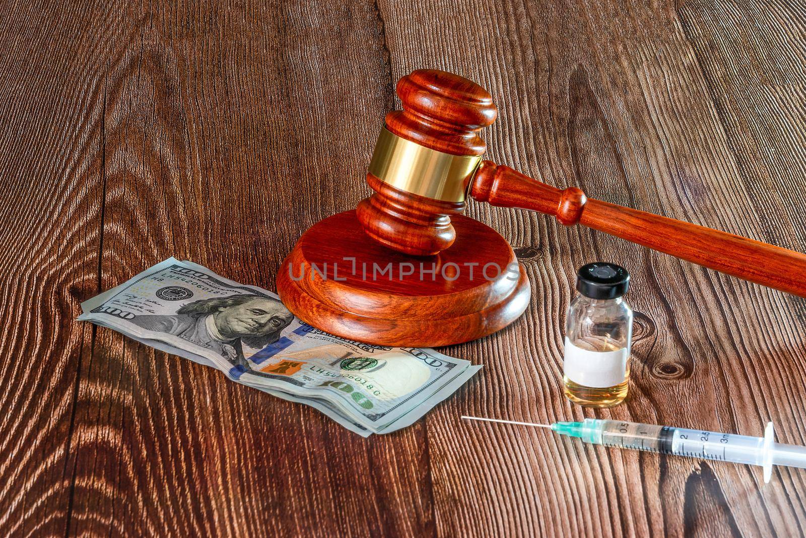 Judges hammer, Dollar notes, syringe and vaccine bottle on a wooden background. Concept for a medical judgment. High quality photo