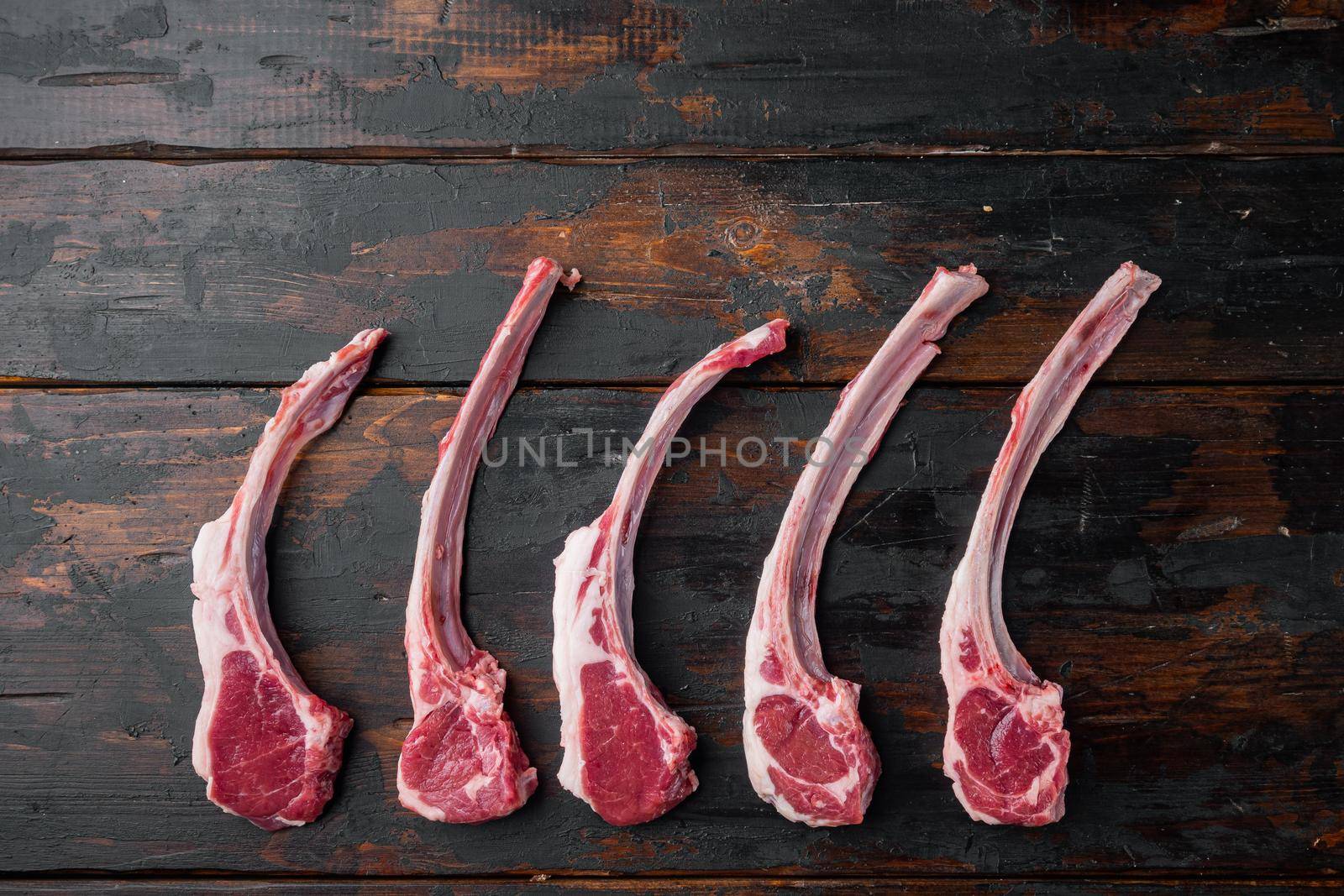 Raw fresh lamb ribs, on old dark wooden table background, top view flat lay , with copyspace and space for text by Ilianesolenyi