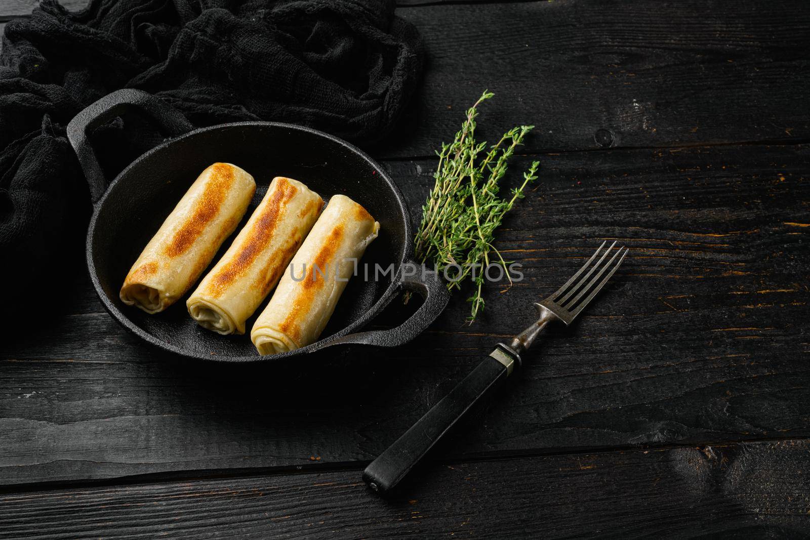 Georgian crepes stuffed on black wooden table background, with copy space for text by Ilianesolenyi