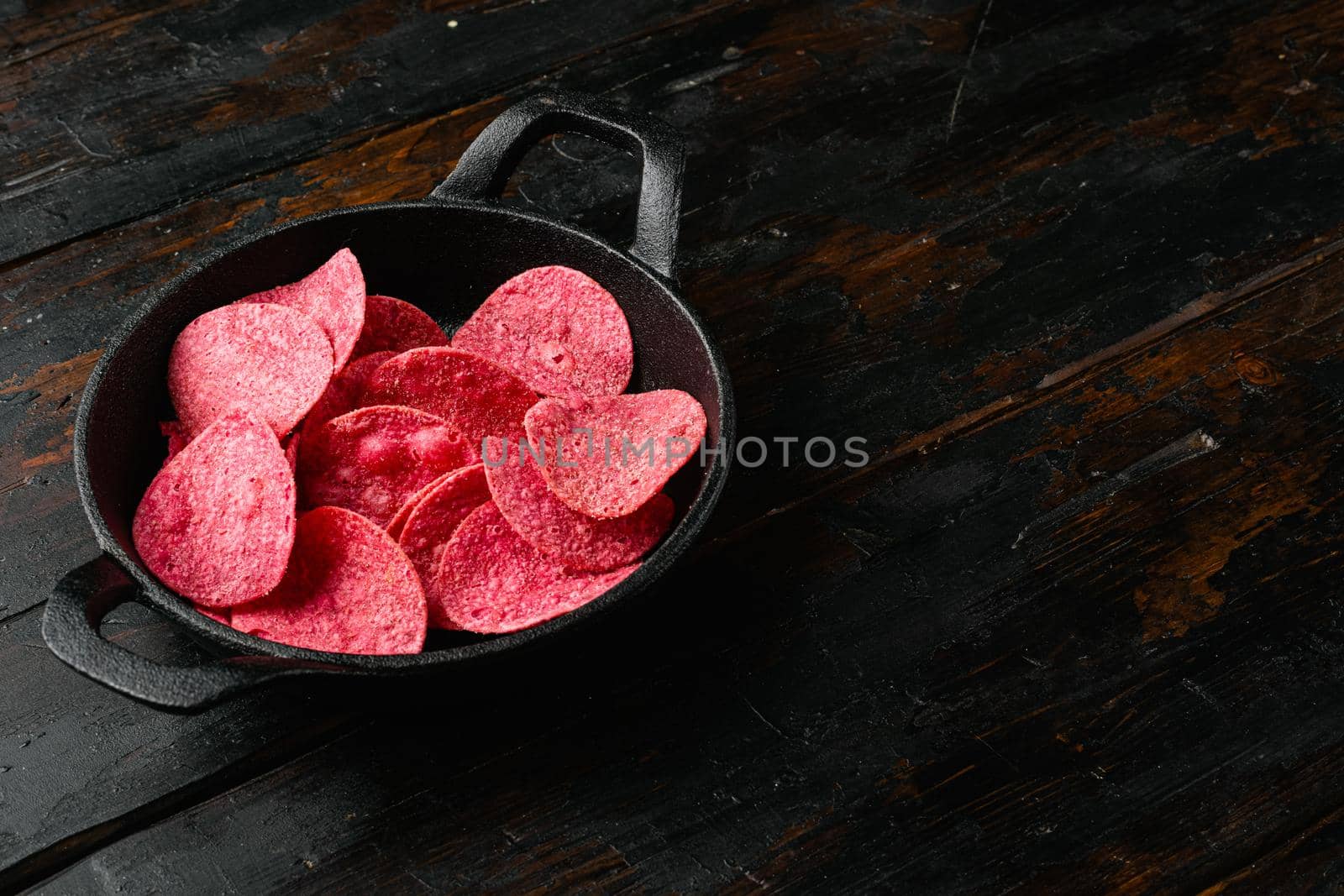 Sweet Southern Heat BBQ Flavored Red Potato Chips, on old dark wooden table background, with copy space for text
