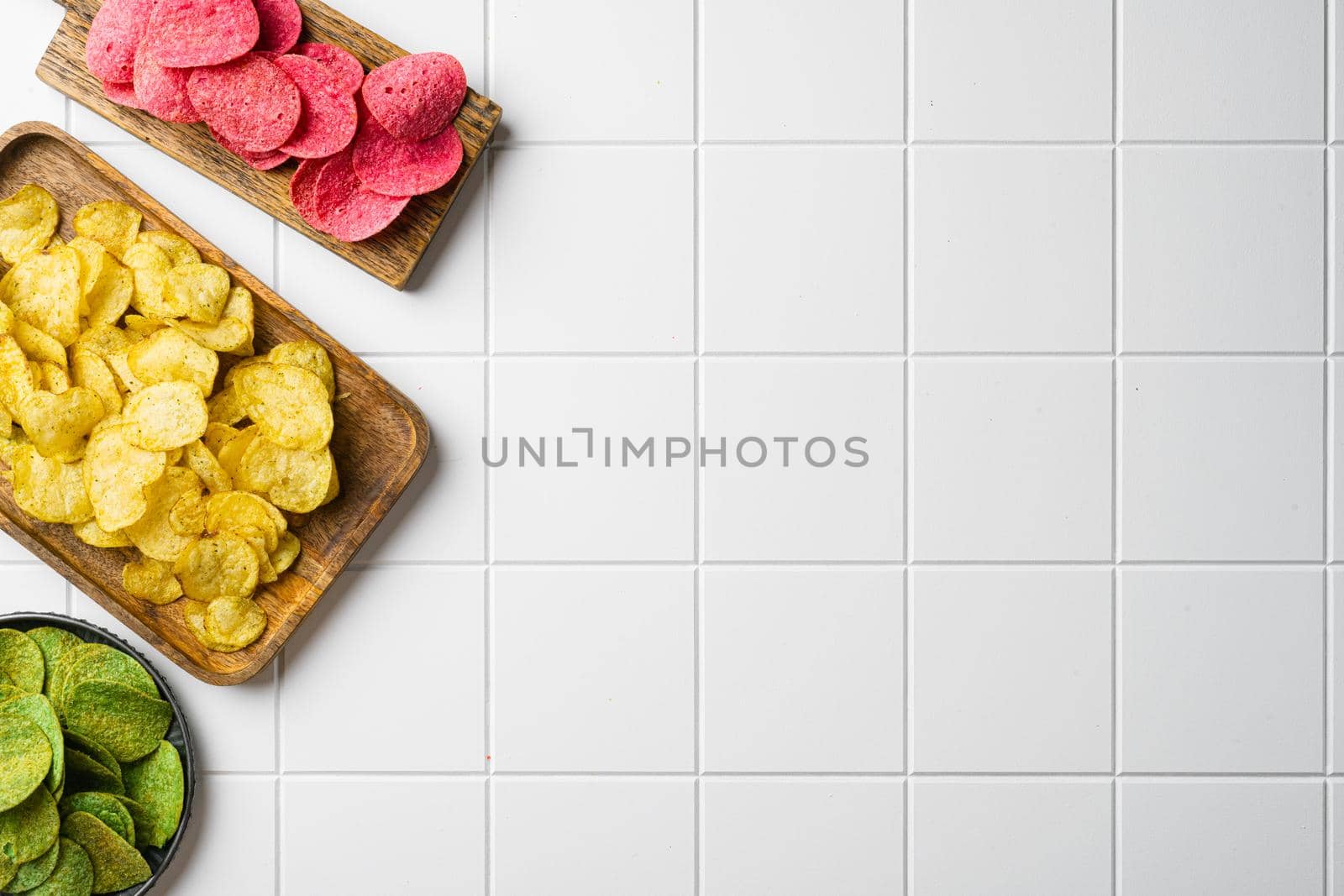 Variation different potato chips on white ceramic squared tile table background, top view flat lay, with copy space for text by Ilianesolenyi